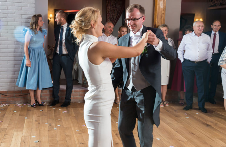 Energia i radość na parkiecie podczas pierwszego tańca pary młodej – dynamiczny kadr z reportażu ślubnego
