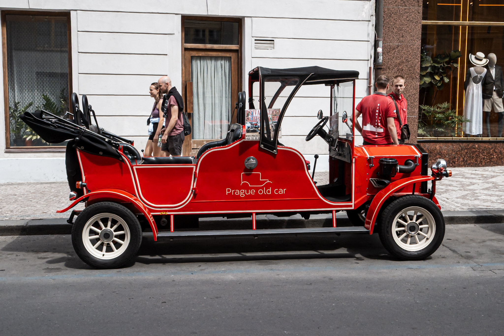 Czerwony zabytkowy samochód „Prague old car” zaparkowany na ulicy w centrum Pragi